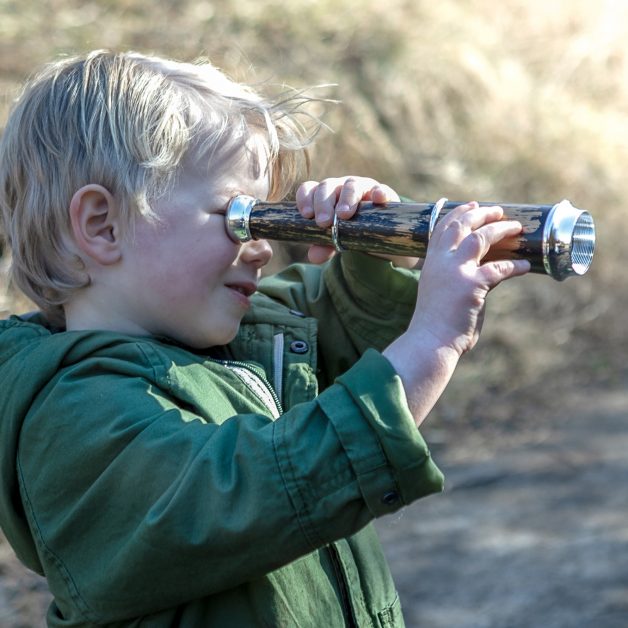 Boy at field trip looking through telescope.
