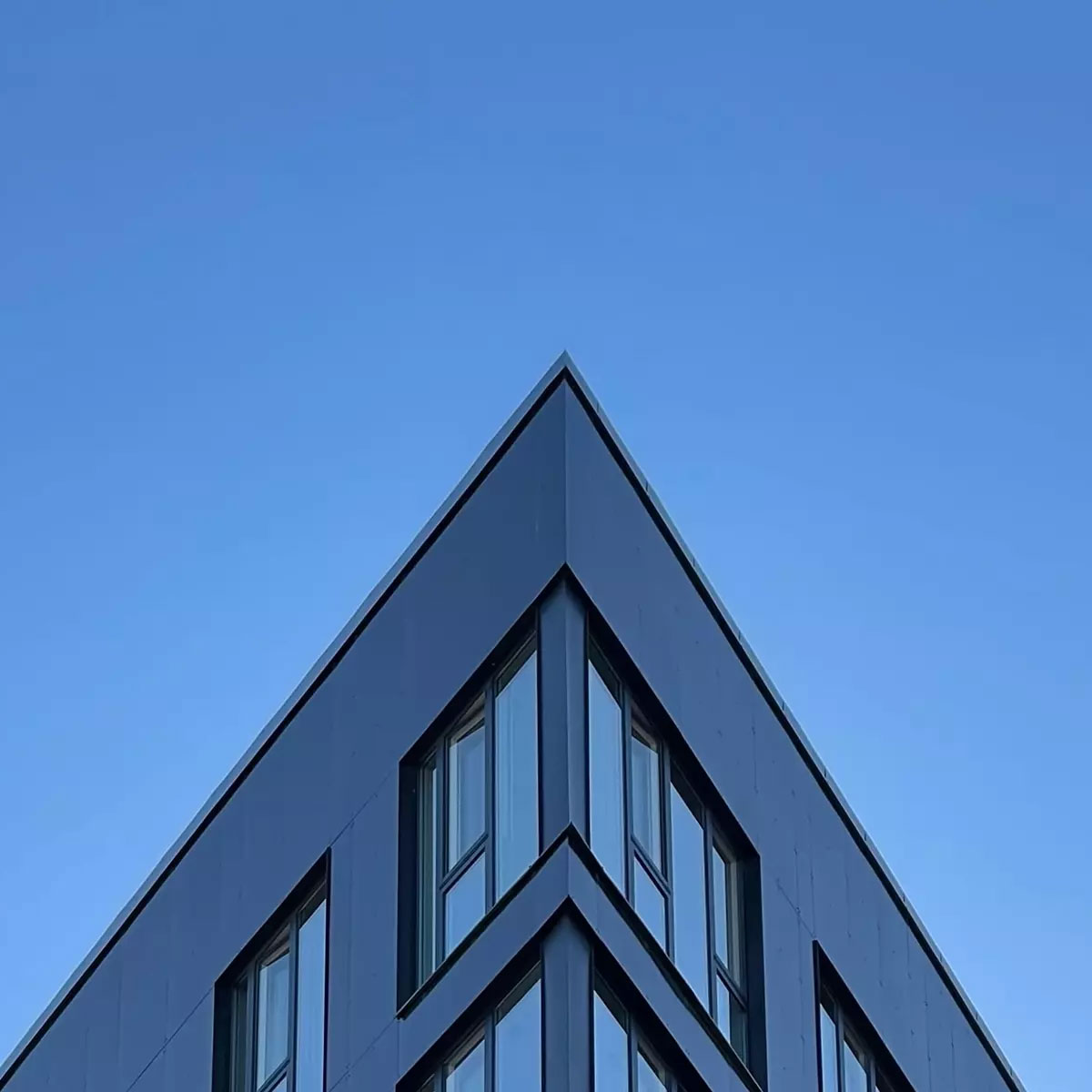 A corner on a building in front of a deep blue sky