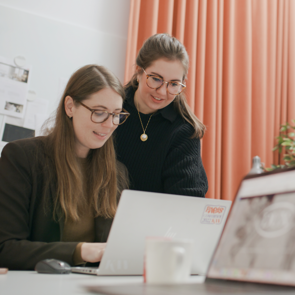 two women working on a computer in a meeting