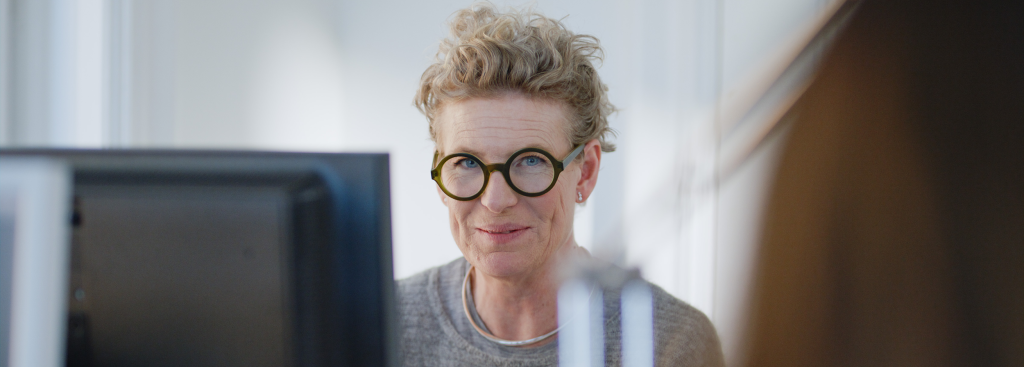 a woman with glasses looking into the camera