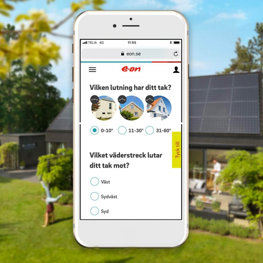 Mobiltelefon som visar E.ONs solcellskalkyl, bild på hus med solceller i oskärpa i bakgrunden.